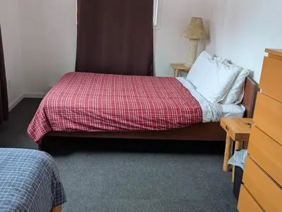 a bedroom with a bed with a red and white blanket at Twin Peaks Resort in Valemount