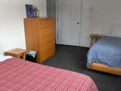 a bedroom with two beds and a dresser with a red blanket at Twin Peaks Resort in Valemount