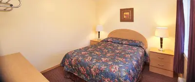 a hotel room with a bed and two night stands at Black Sea Motel in Penticton