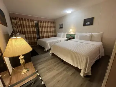 a hotel room with two beds and a lamp at Holiday House Motel in Ladysmith