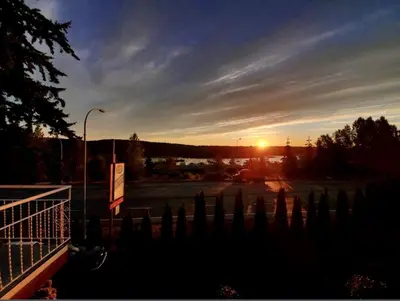 a sunset over a parking lot with a fence at Holiday House Motel in Ladysmith