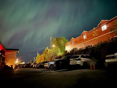 a group of cars parked in a parking lot at night at Holiday House Motel in Ladysmith