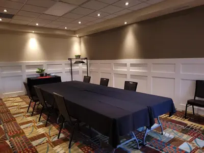a conference room with a blue table and chairs at Neighbourhood Inn Hotels in Bonnyville in Bonnyville