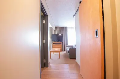 a hallway leading to a living room with a television at Neighbourhood Inn Hotels in Bonnyville in Bonnyville