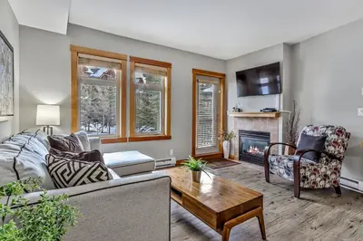 a living room with a couch and a fireplace at Suites with Pool & Hot tubs managed by Little Sister Getaways in Canmore