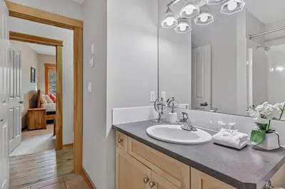 a bathroom with a sink and a mirror at Suites with Pool & Hot tubs managed by Little Sister Getaways in Canmore
