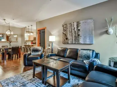 a living room with a couch and a table at Suites with Pool & Hot tubs managed by Little Sister Getaways in Canmore