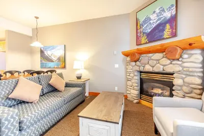 a living room with a couch and a fireplace at Lizard Creek Lodge in Fernie