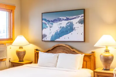 a hotel room with a bed with two lamps at Lizard Creek Lodge in Fernie