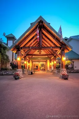 a large log building with a lit up entrance at Lizard Creek Lodge in Fernie