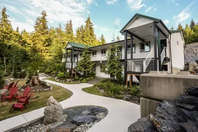 a house with a garden and a walkway at West Coast Trail Lodge in Port Renfrew