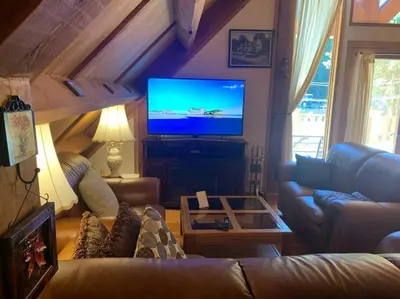 a living room with a couch and a flat screen tv at Owl Street Lodge in Hope