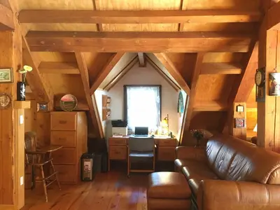 a living room with a leather couch and a desk at Owl Street Lodge in Hope