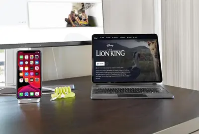 a laptop computer sitting on a desk next to a cell phone at 5 STAR Business Luxury Homeshare in Edmonton