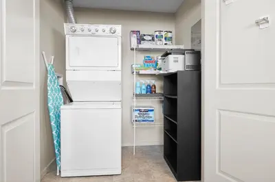 a small kitchen with a white refrigerator and a shelf at 5 STAR Business Luxury Homeshare in Edmonton
