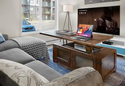 a living room with a couch and a laptop on a table at 5 STAR Business Luxury Homeshare in Edmonton