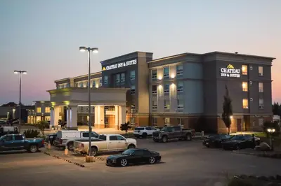 a building with cars parked in a parking lot at Chateau Inn & Suites Bonnyville in Bonnyville
