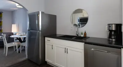 a kitchen with a stainless steel refrigerator and a sink at Stoneshire Guesthouse in Clearwater