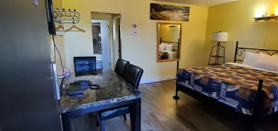 a hotel room with a bed and a desk with a computer at Port-O-Call Inn in Nanaimo