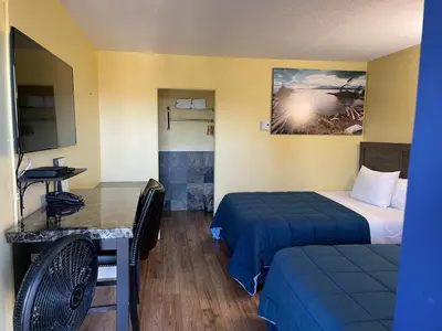 a small room with two beds and a table at Port-O-Call Inn in Nanaimo