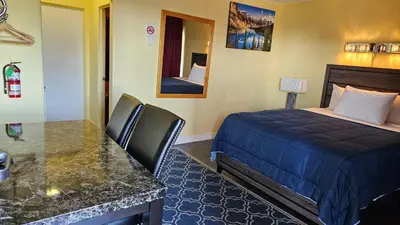 a hotel room with a bed and a desk and a bed sidx sidx sidx sidx at Port-O-Call Inn in Nanaimo