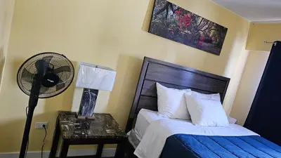 a bedroom with a bed with a fan and a night stand at Port-O-Call Inn in Nanaimo