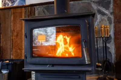 a stove with a fire inside of it at Red Shutter Inn in Rossland