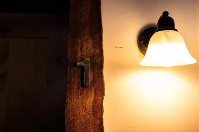a light on the side of a wall with a lamp at Red Shutter Inn in Rossland
