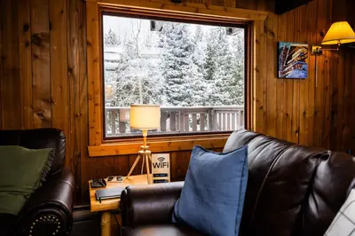 a living room with a couch and a window at Red Shutter Inn in Rossland