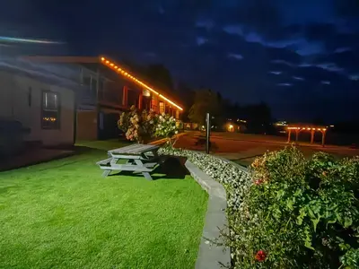 a picnic table in the grass near a building at night at Sea Edge Beachside Hotel in Parksville