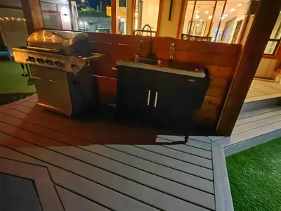 a kitchen with a stove and a sink on a deck at Sea Edge Beachside Hotel in Parksville