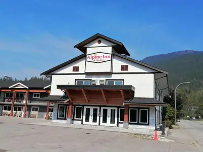 a large white building with a alpine inn sign on it at Alpine Inn & Suites in Revelstoke