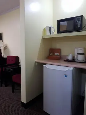 a kitchen with a white refrigerator and a microwave at Alpine Inn & Suites in Revelstoke