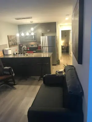 a living room with a couch and a kitchen at Home Sweet Condo in Calgary