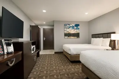 a hotel room with two beds and a flat screen tv at Days Inn by Wyndham Wainwright in Wainwright
