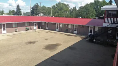 an empty parking lot in front of a building with a red roof at Viking Lamplighter Motel in Viking
