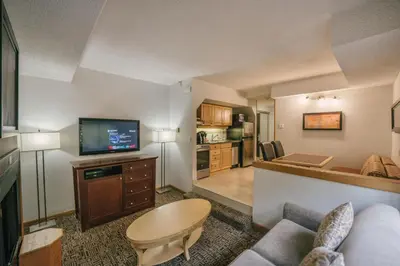 a living room with a couch and a tv at Mountain Side Hotel Whistler by Executive in Whistler