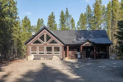 a house with a garage in the woods at Wolf Den in Valemount