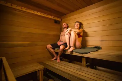 a man and woman sitting in a sauna at The Raging Elk Adventure Lodging in Fernie