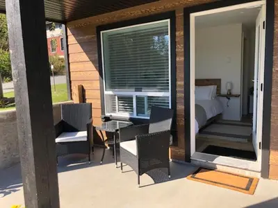 a patio with a bed and chairs and a table at Sounds of the Sea in Ucluelet