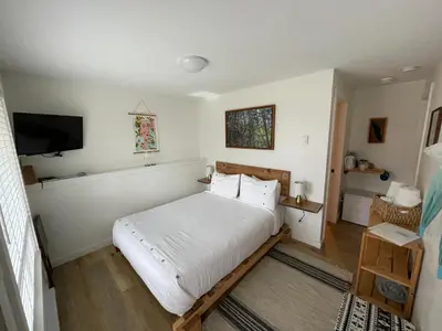 a bedroom with a bed and a flat screen tv at Sounds of the Sea in Ucluelet