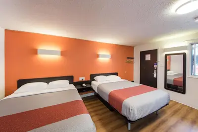 two beds in a room with orange walls at Motel 6-Cranbrook, BC in Cranbrook