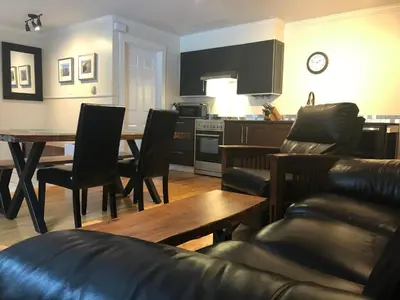 a kitchen and living room with a table and chairs at Canadian Rockies Inn - Adults only in Field
