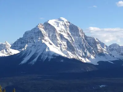 a snow covered mountain with trees in front of it at Canadian Rockies Inn - Adults only in Field