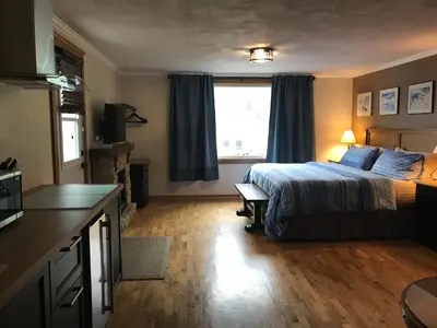 a hotel room with a bed and a kitchen and a kitchen at Canadian Rockies Inn - Adults only in Field