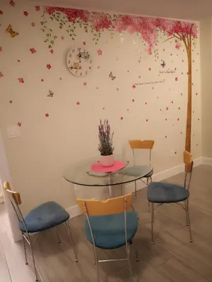 a table and chairs in a room with flowers on the wall at Metropolis MetroTown Area lovely place 2 or 1 bedrooms suite in New Westminster