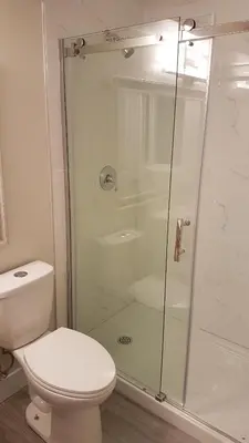 a bathroom with a toilet and a glass shower at Metropolis MetroTown Area lovely place 2 or 1 bedrooms suite in New Westminster