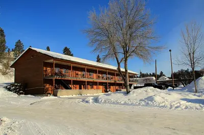 a large building with snow on the ground in front of it at Cariboo Lodge in Clinton