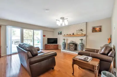 a living room with leather furniture and a fireplace at Orchid House near Vancouver YVR Airport in Richmond