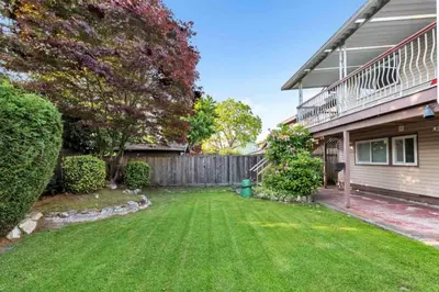 a yard in front of a house with a fence at Orchid House near Vancouver YVR Airport in Richmond